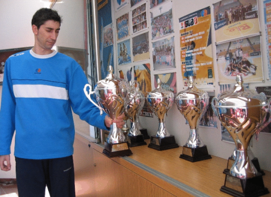 Lisaro Gómez coloca el trofeo de campeón de la última fase SUB20 junto al resto de copas que demuestran la gran trayectoria del equipo en la competición